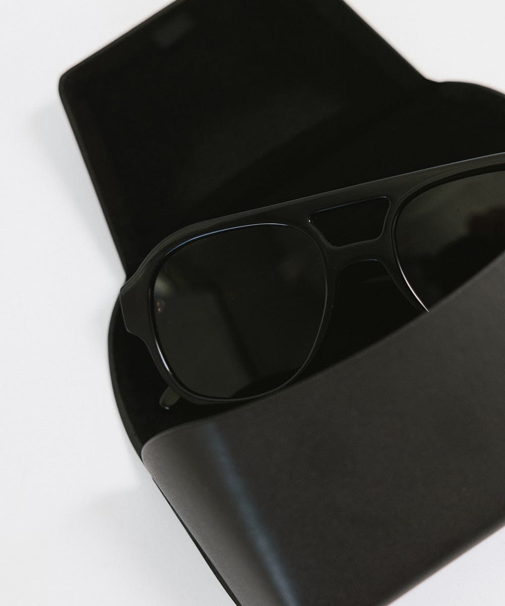 Black aviator sunglasses in a black sunglass case on a plain background #color_black