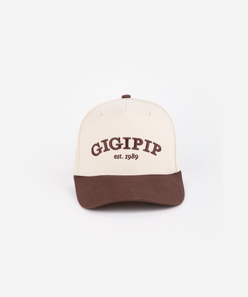A cream and chocolate brown trucker hat with 'GIGI PIP' embroidered in chocolate brown on the front against a plain background #color_cream - chocolate brown