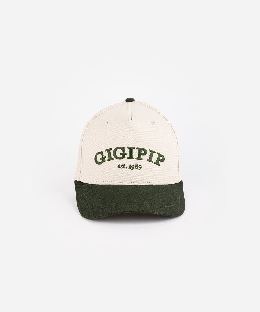 A cream and dark green trucker hat with 'GIGI PIP' embroidered in dark green on the front against a plain background #color_cream - dark green