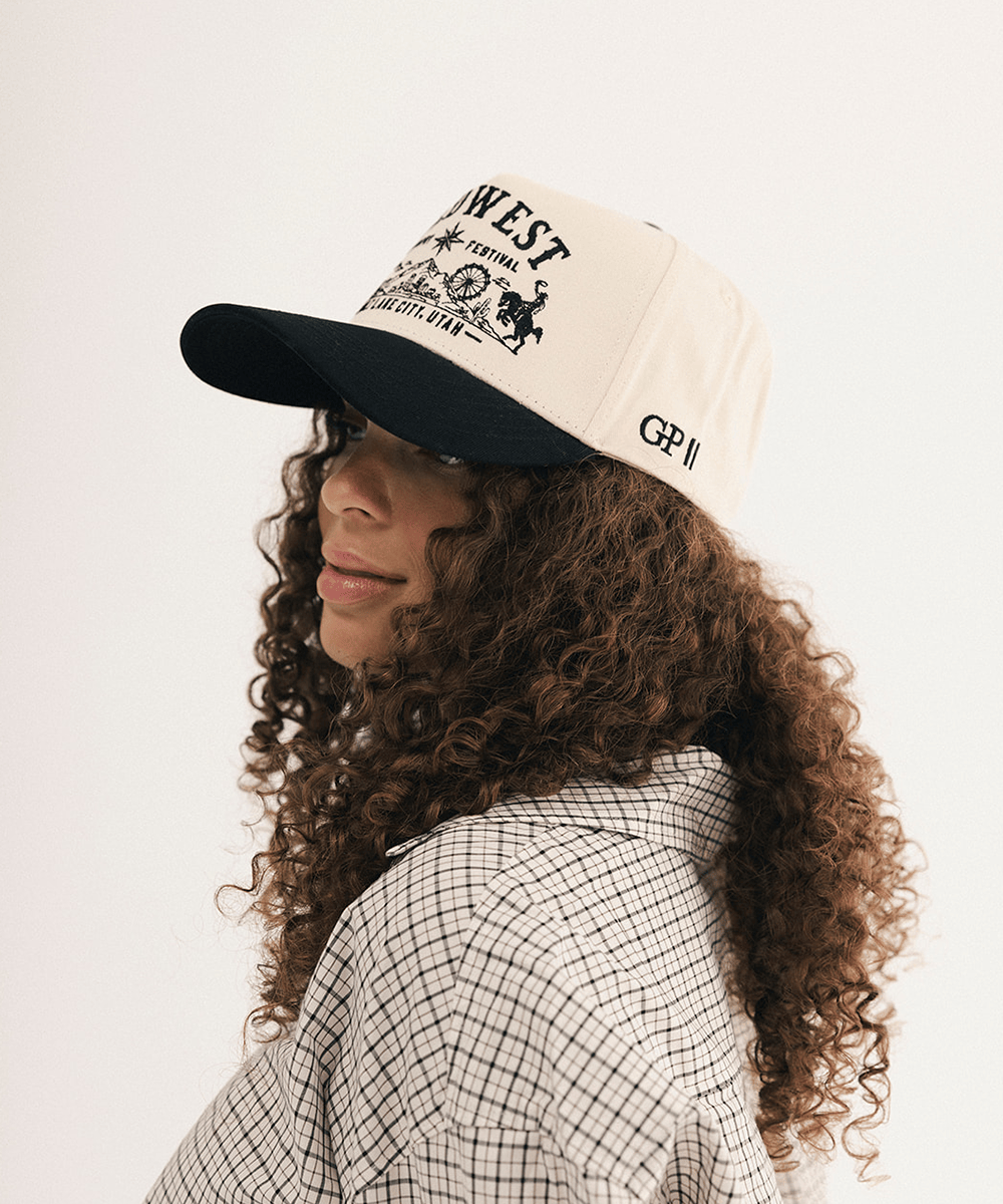 Woman's side view wearing a black and white baseball cap and plaid shirt in a white background #color_cream - black
