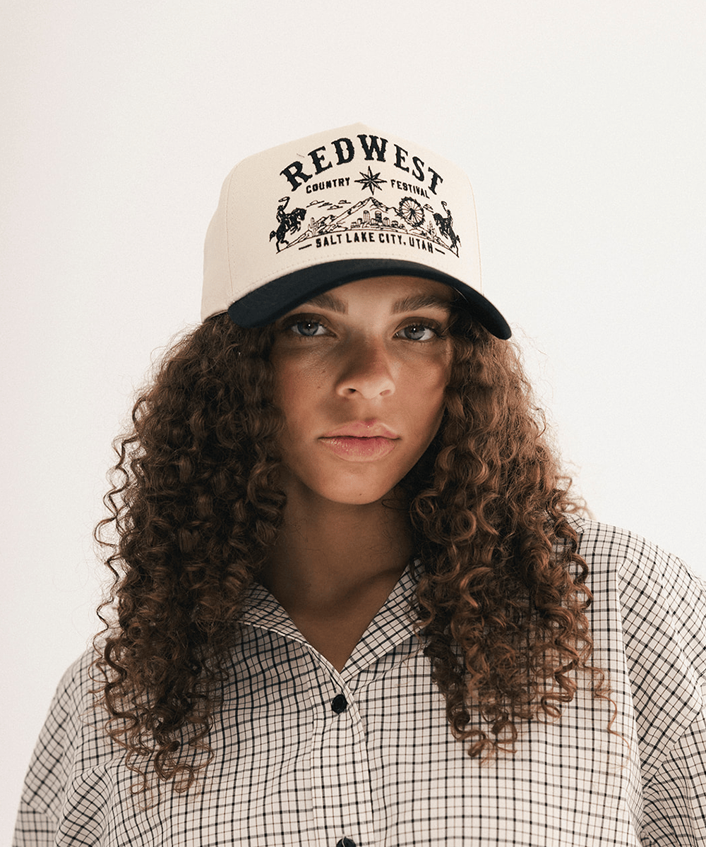 Woman wearing a black and white baseball cap and plaid shirt in a white background #color_cream - black