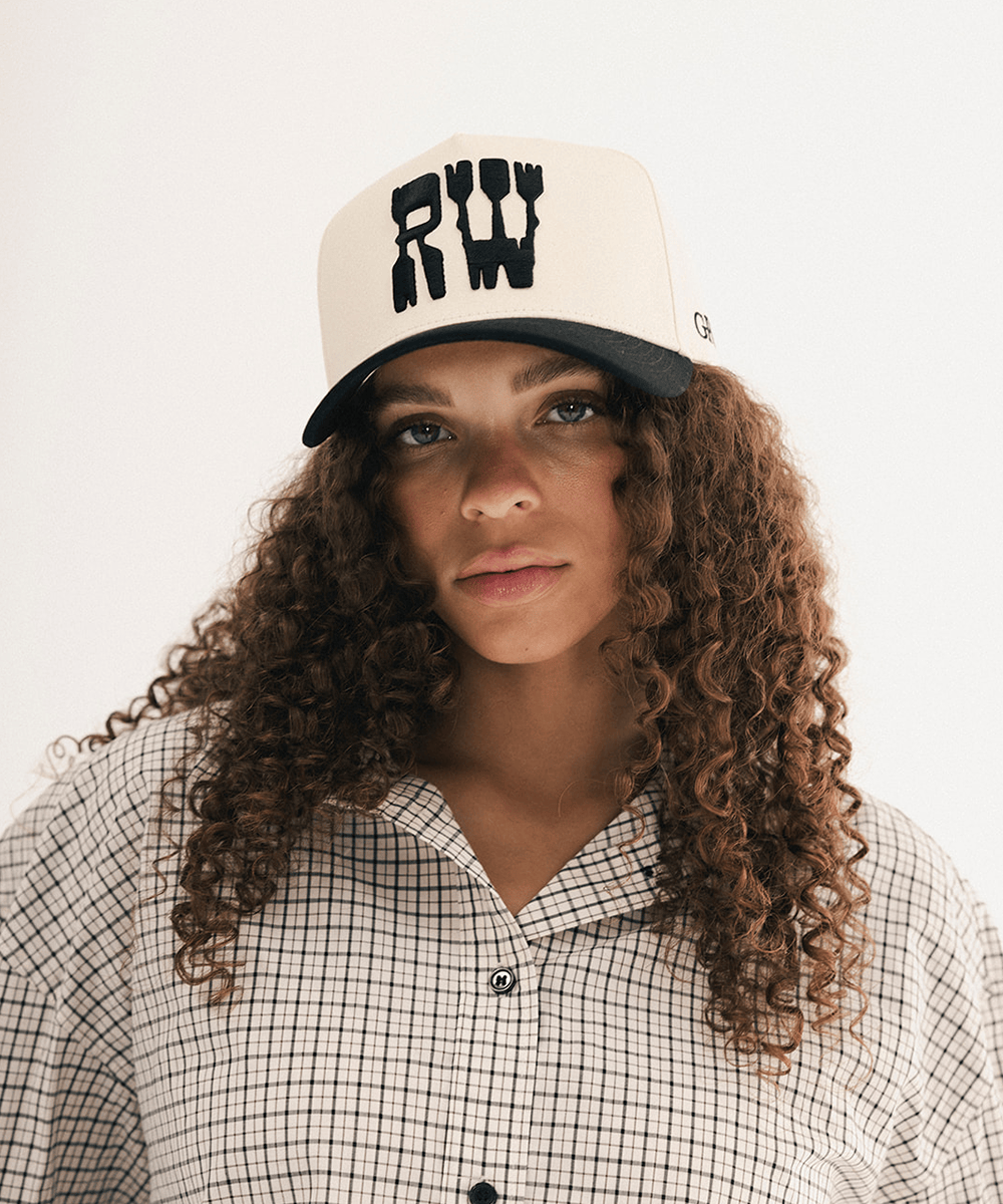 Woman wearing a black and white baseball cap and plaid shirt in a white background #color_cream - black