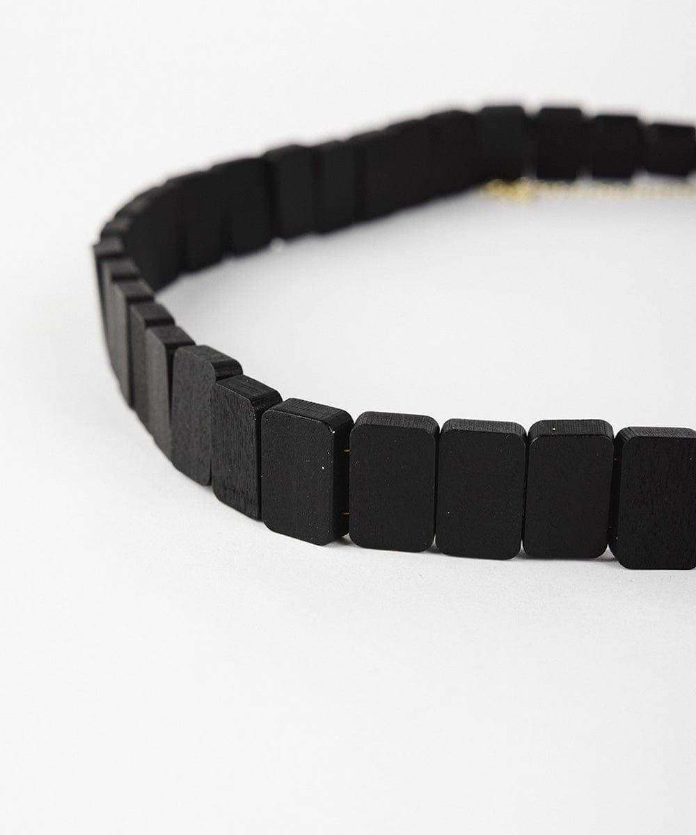 A black wooden beaded band on a plain background #color_black