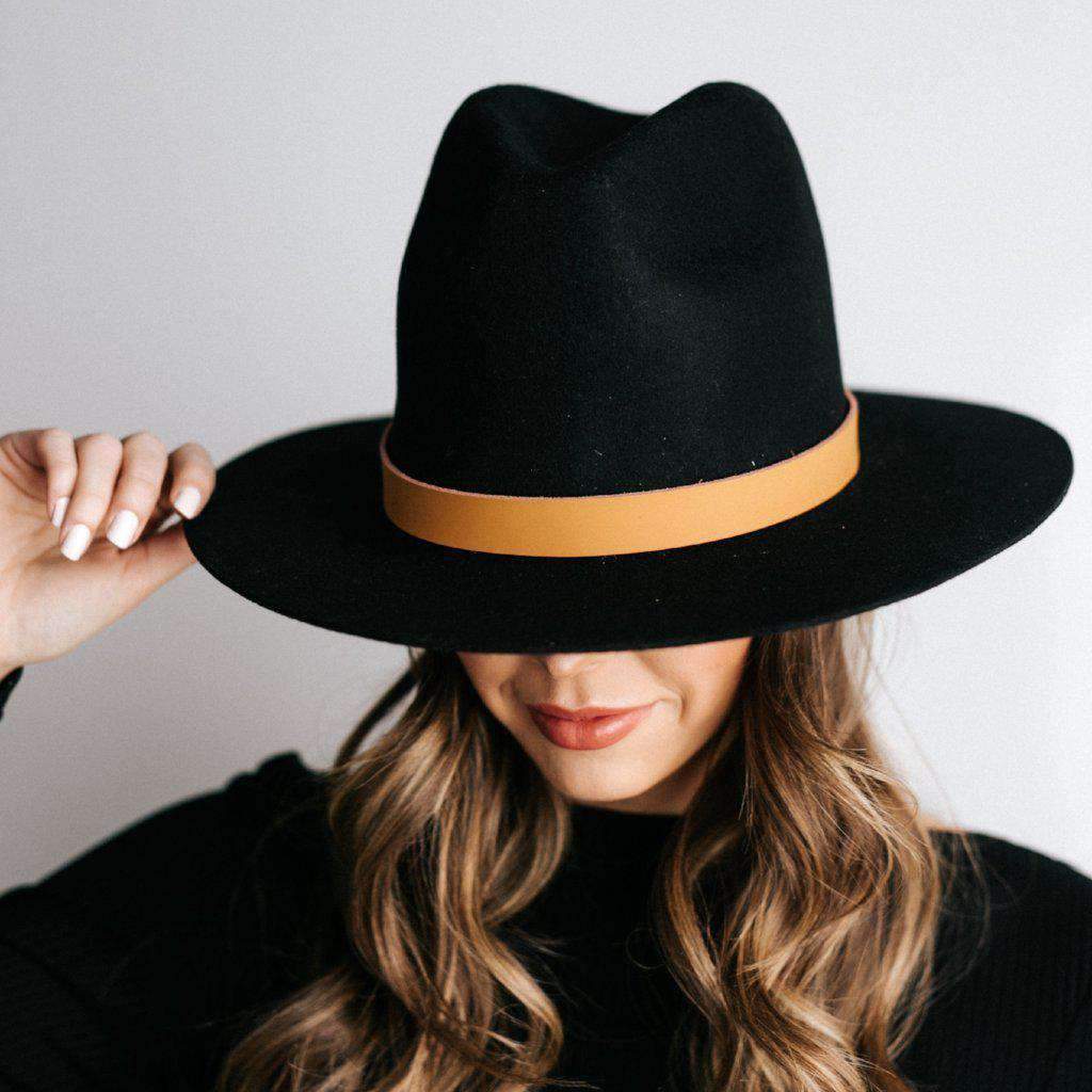 Woman wearing a black hat with a camel colored leather adjustable chain band against a plain background #color_camel