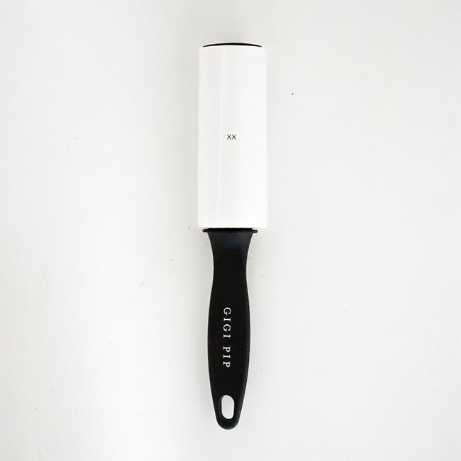 A lint roller with the text 'GIGI PIP' on a plain background #color_black