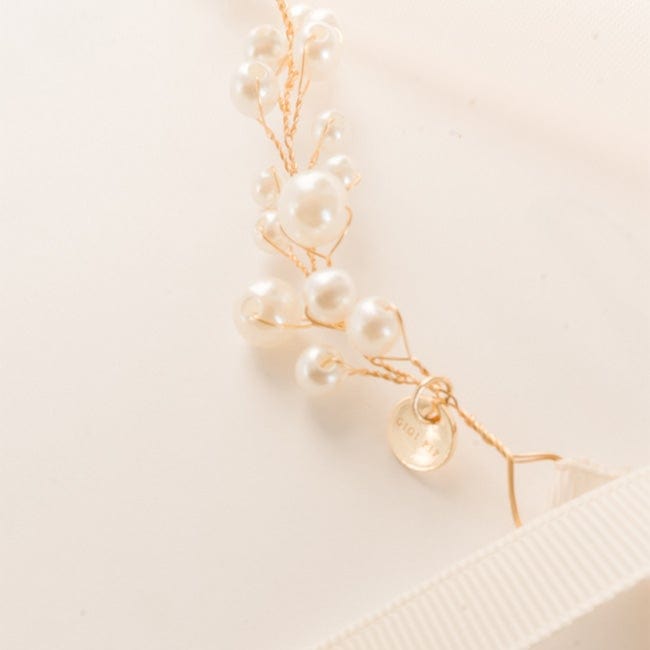 Close up image of a gold decorative hat band with beads on a plain background #color_gold