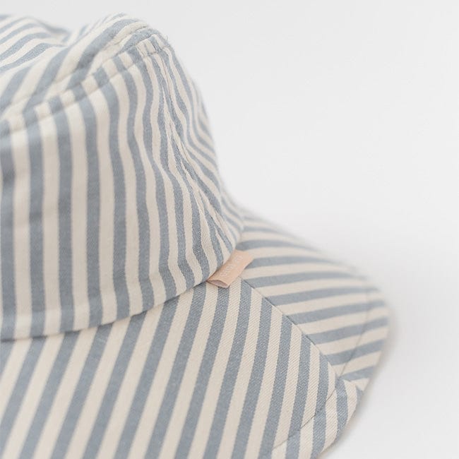 Close up image of a blue and white striped bucket hat on a plain background #color_striped-blue