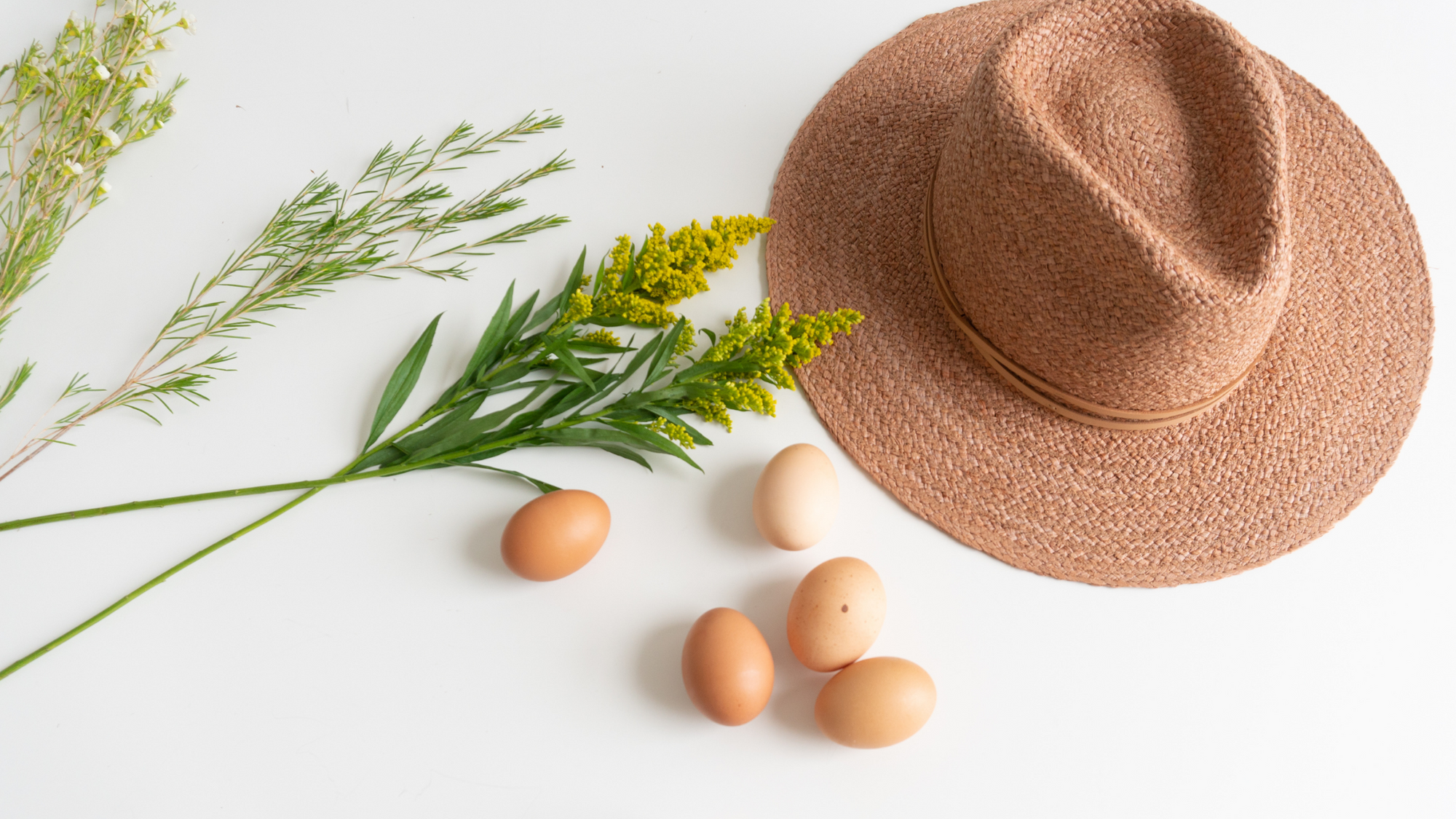 hat next to eggs and flowers