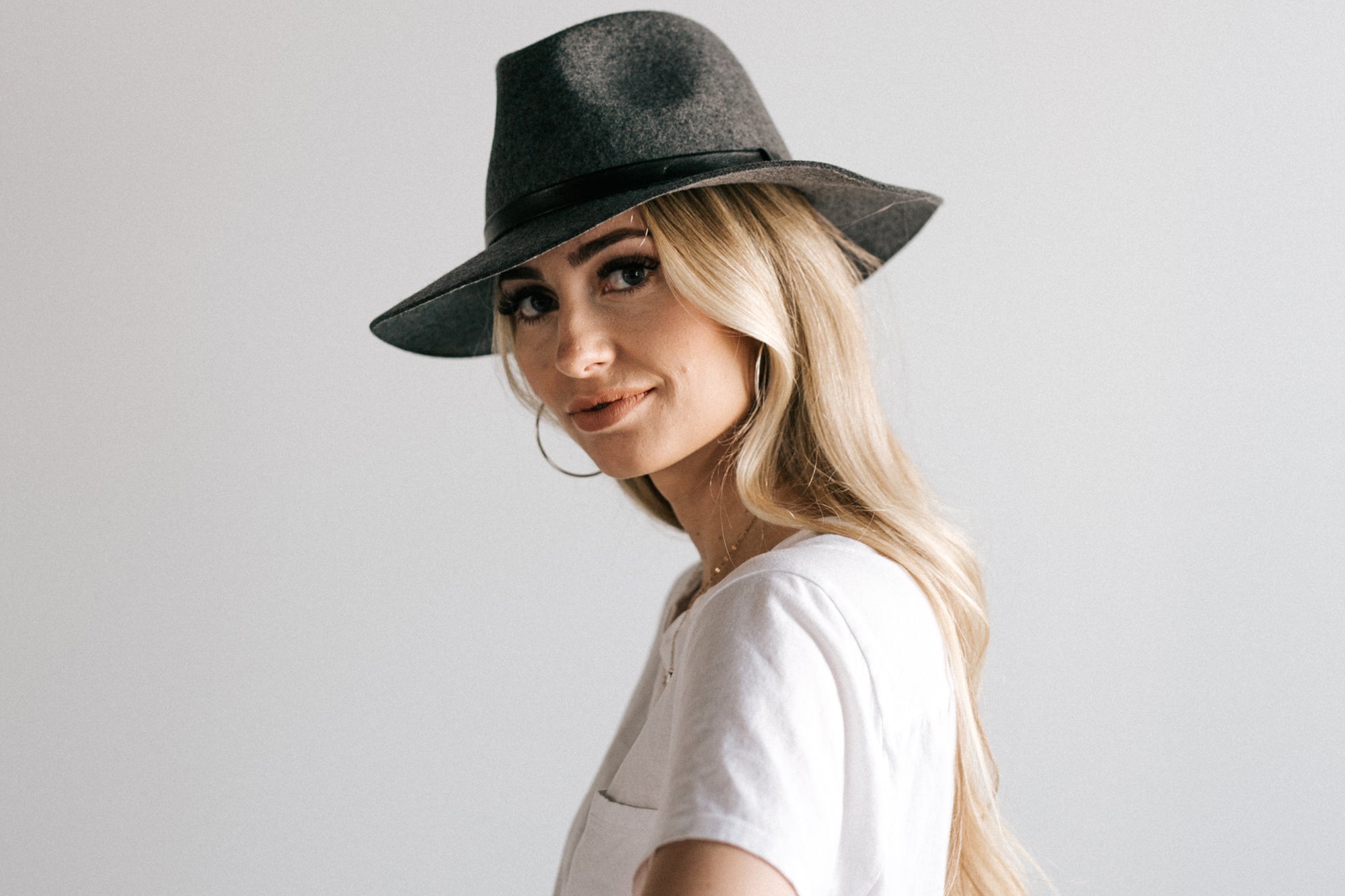 Woman in felt hat smiling at camera