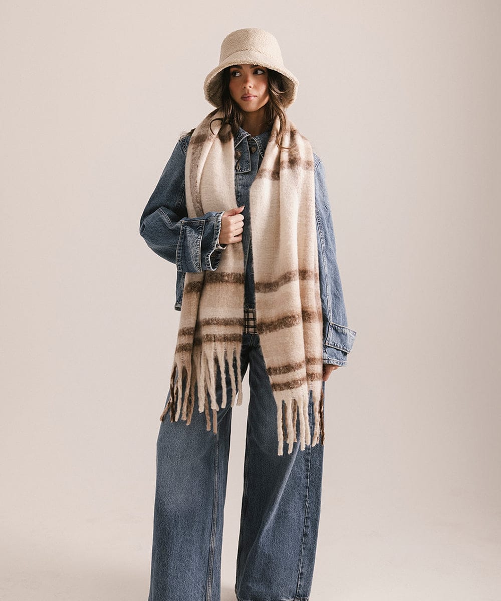 Person wearing a plaid scarf, denim jacket, and bucket hat on a plain background #color_ cream - brown plaid