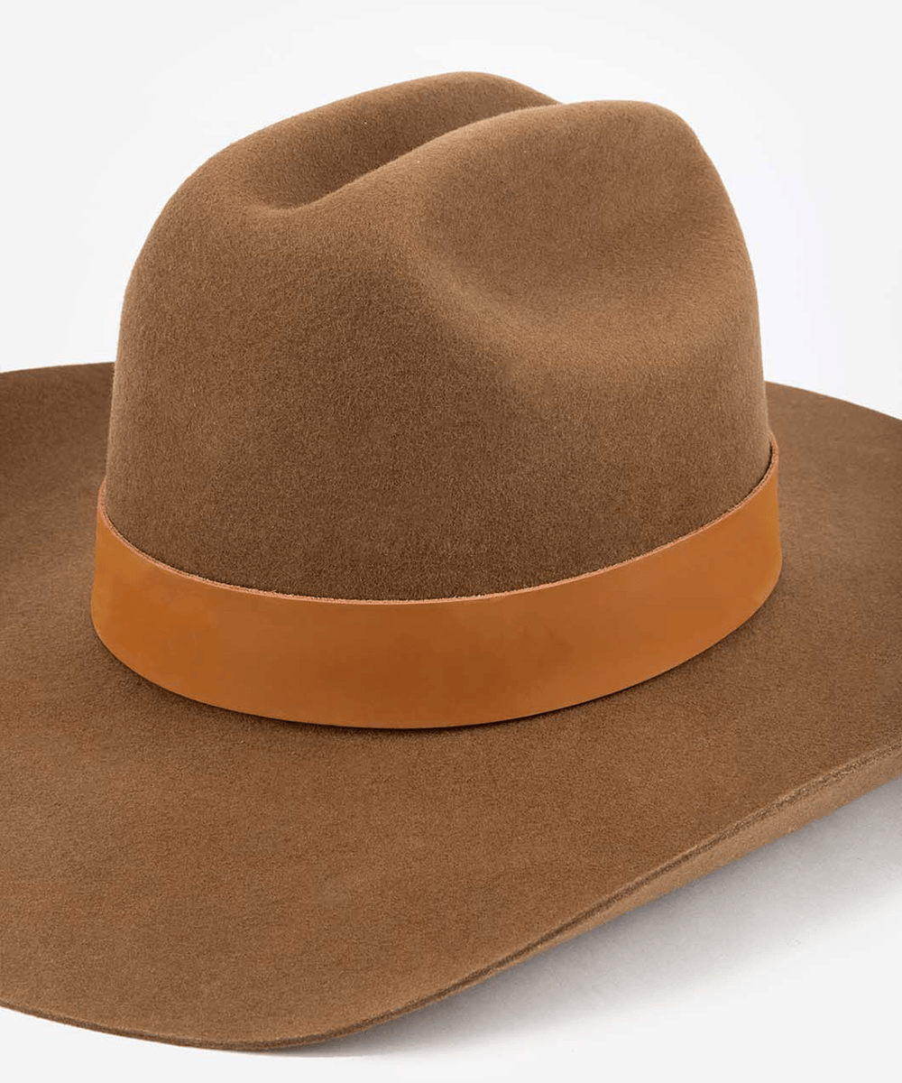 Brown cowboy hat with a leather band on a white background #color_cognac