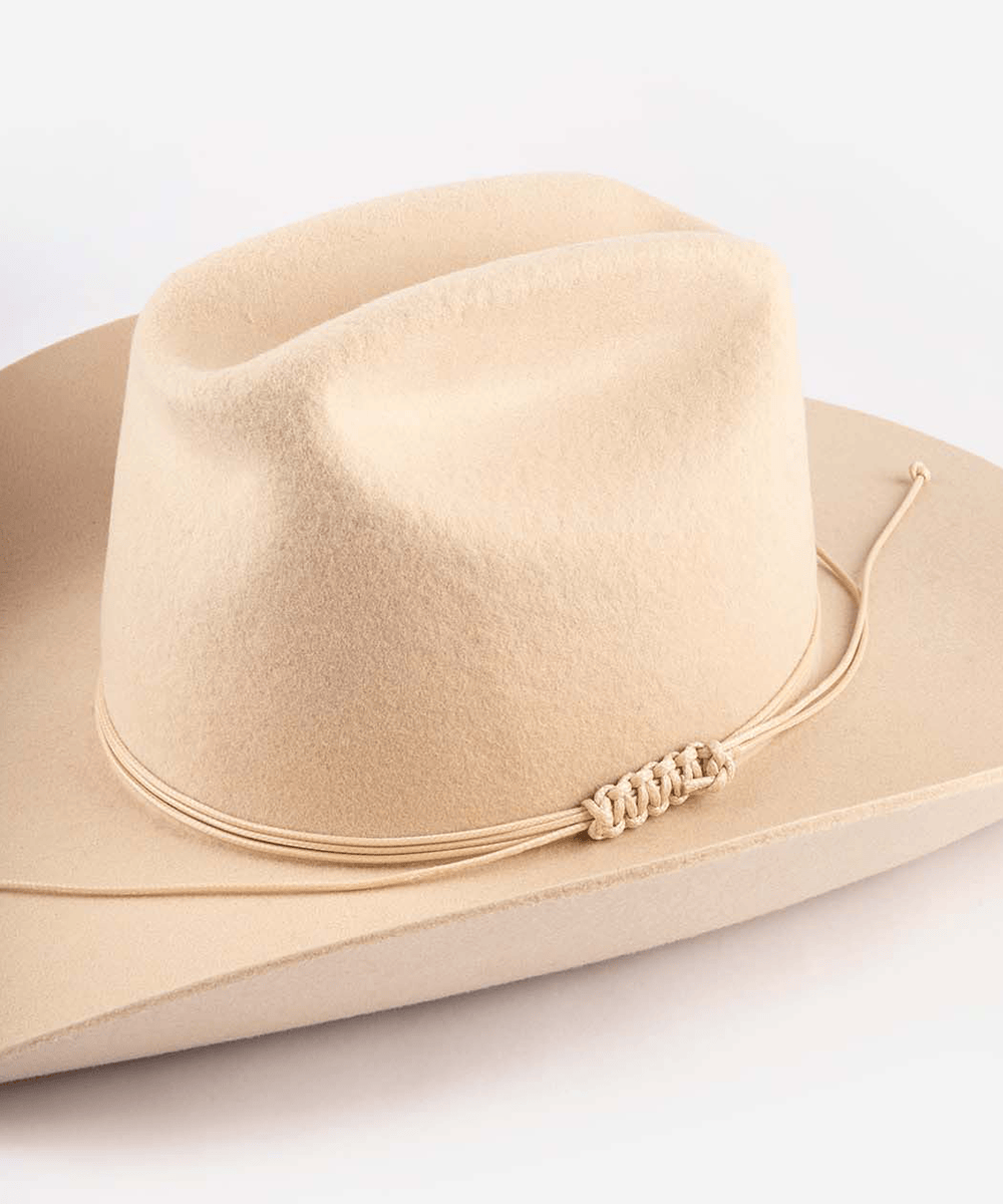 Beige cowboy hat with string triple wrap band on a light gray background #color_cream