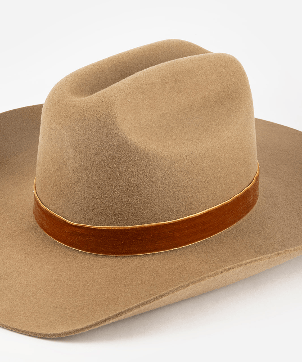 Beige cowboy hat with a camel colored velvet chain band on a white background #color_camel