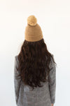 Gigi Pip beanies for women - Mo Pom Beanie - classic knit beanie with a pom on the crown, featuring the Gigi Pip logo on a metal bar on the front fold [tan]