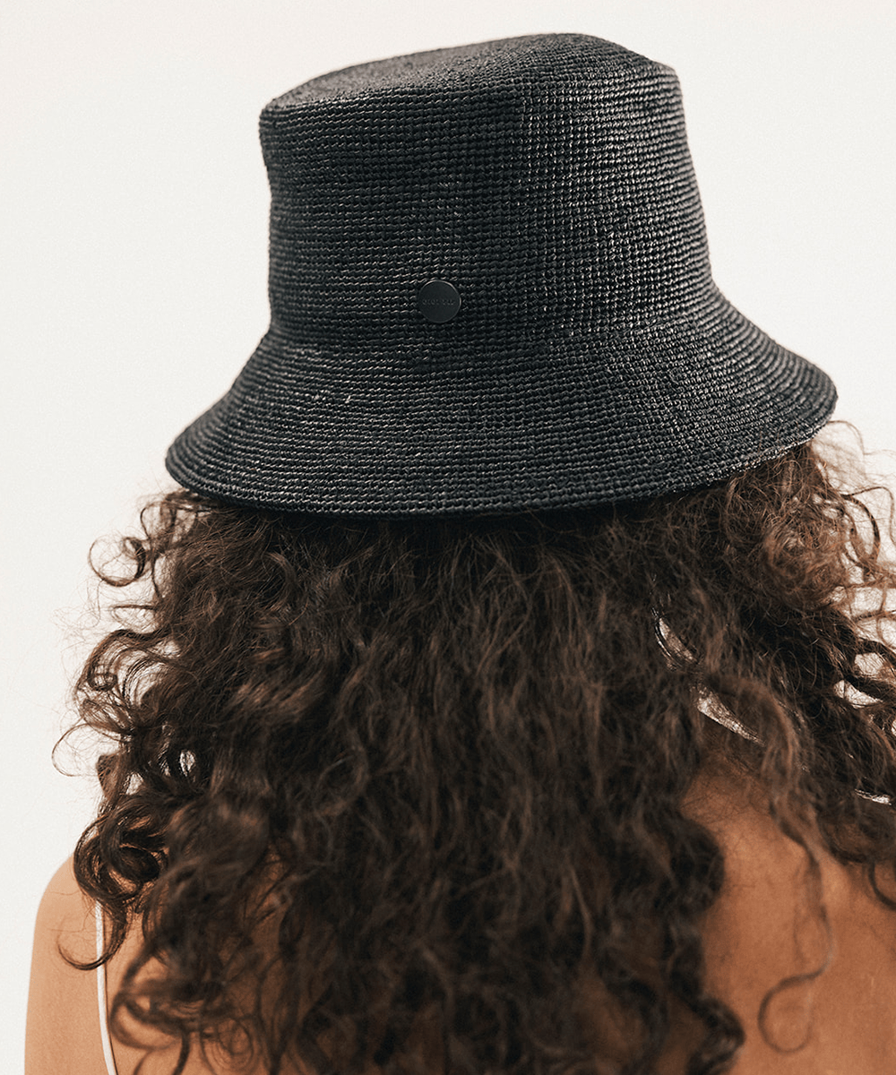 Woman wearing a black bucket hat against a white background #color_black