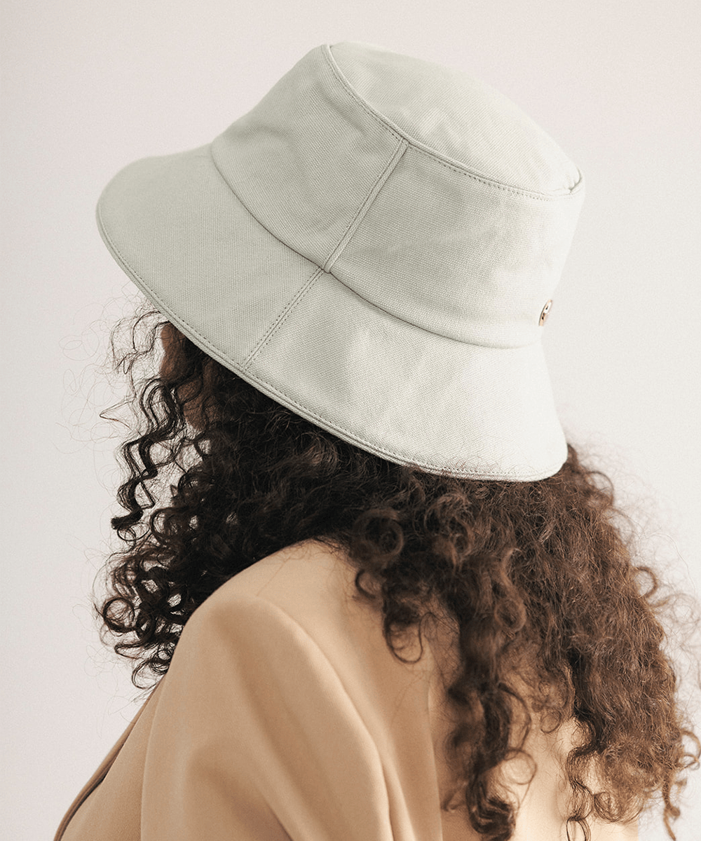 Woman wearing a sage bucket hat with a plain background #color_sage
