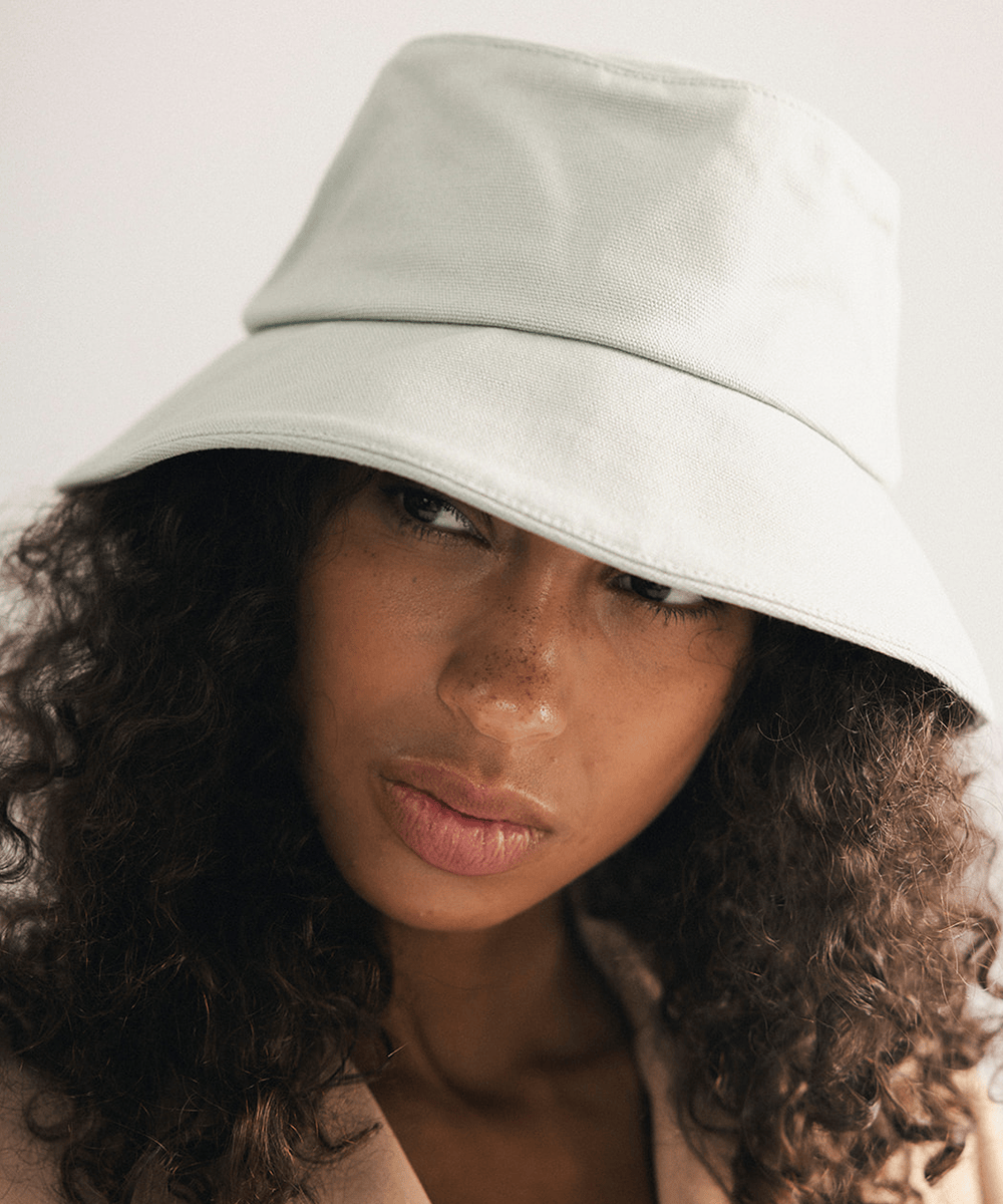 Woman wearing a sage bucket hat with a plain background #color_sage