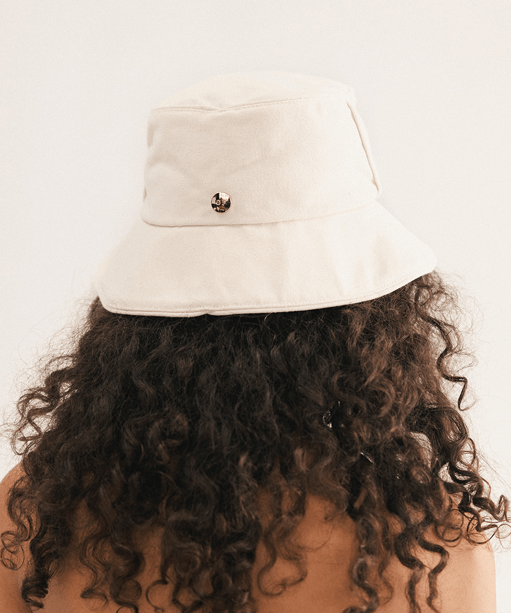Woman wearing a cream bucket hat with a plain background #color_cream