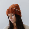 Gigi Pip beanies for women - Vail Beanie - 100% acrylic chunky knit beanie with a comfortable plush inner band, featuring the Gigi Pip logo on a metal bar in the front [burnt orange + cream]