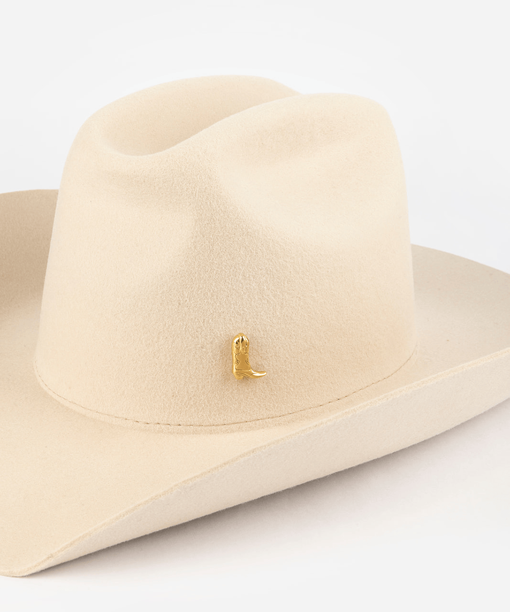 Pink cowboy hat with a gold boot-shaped hat pin on a white background #color_gold