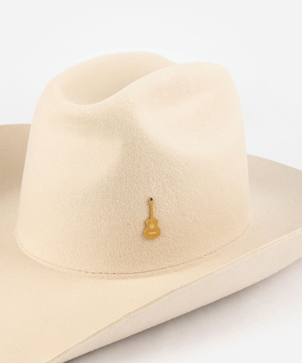Pink cowboy hat with a gold guitar-shaped hat pin on a white background #color_gold