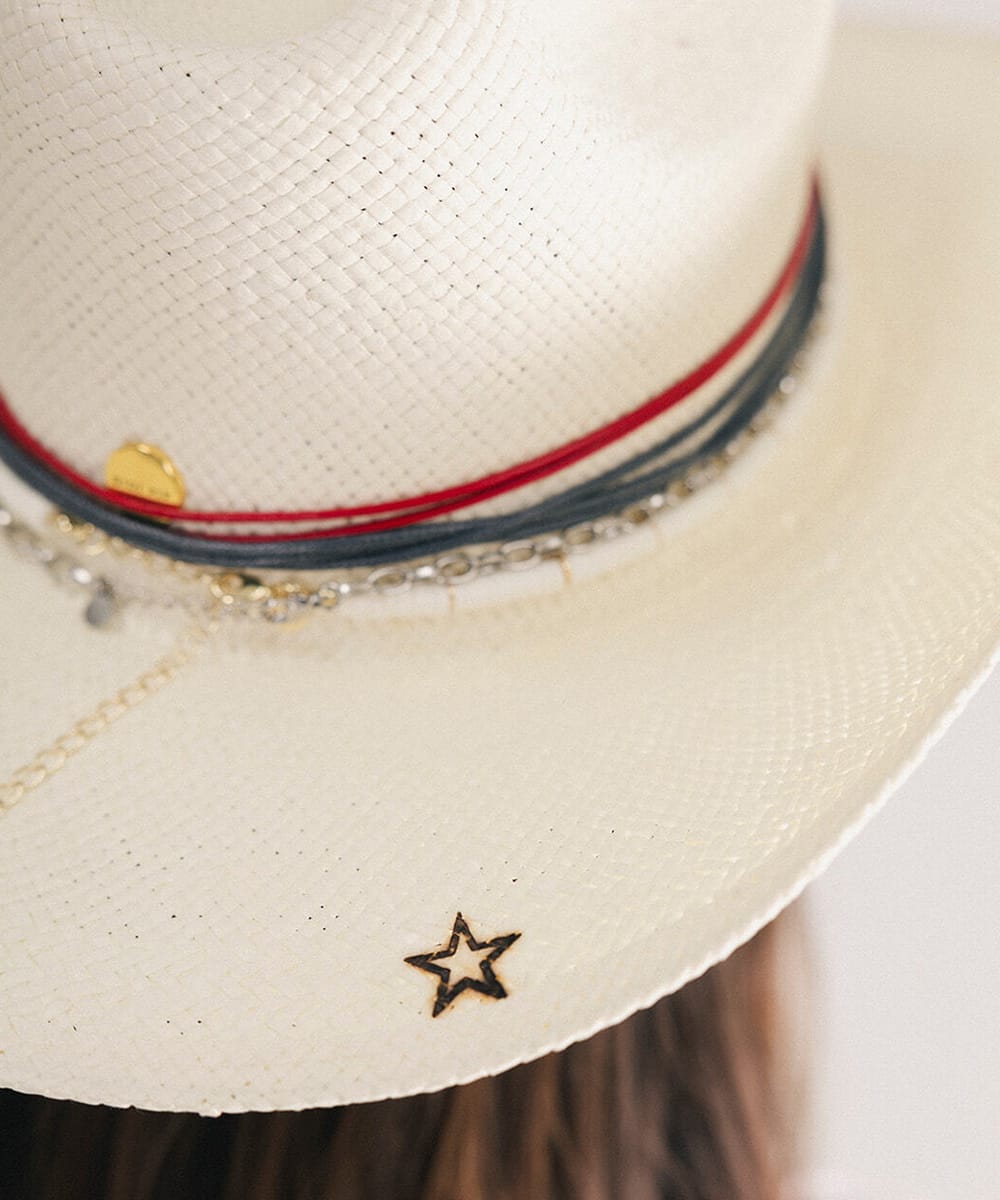 Close-up of a white cowboy hat with decorative band and star detail #color_natural white