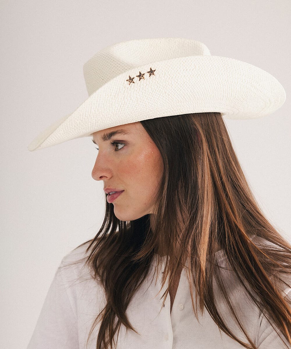 Woman wearing a cowboy hat with decorative three star pins in a plain background #color_natural white