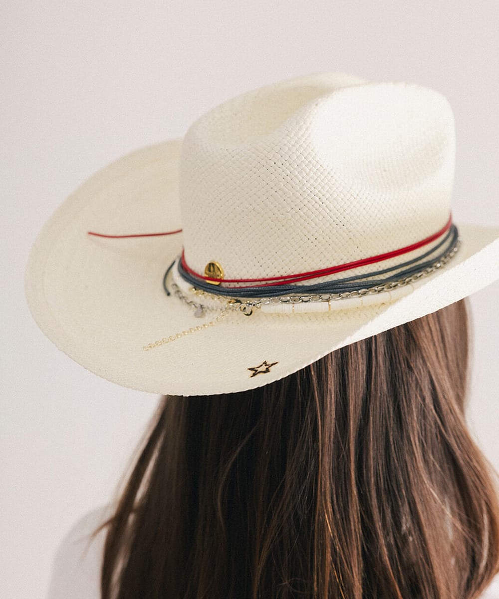 Woman wearing a cowboy hat with decorative bands and branded star in a plain background #color_natural white