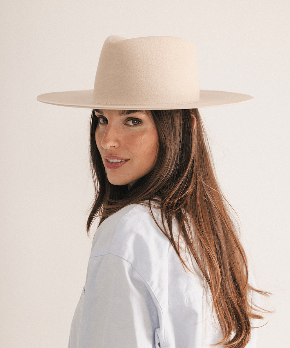 Woman wearing a wide brim felt hat on a white background #color_cream