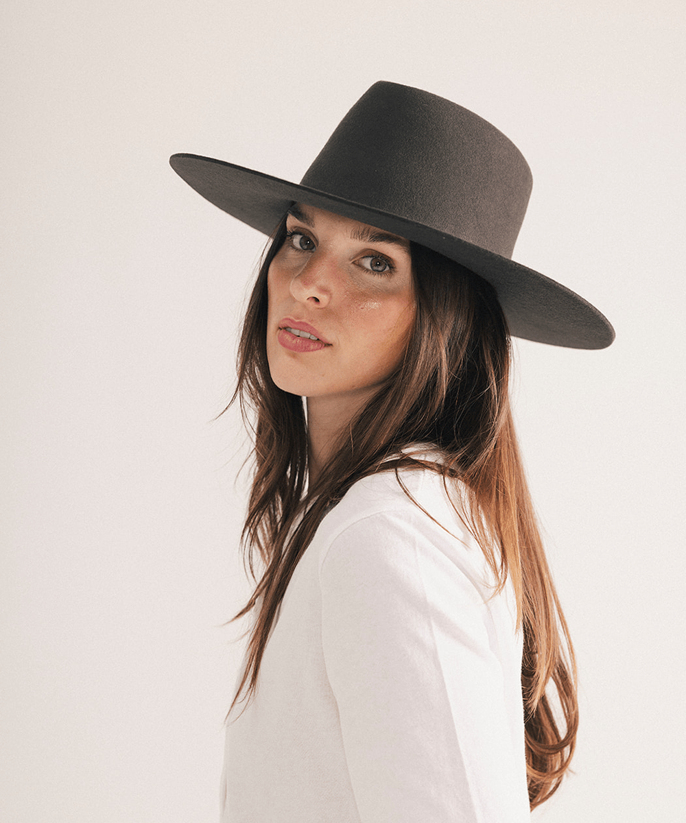 Woman wearing a wide brim felt hat on a white background #color_dark brown
