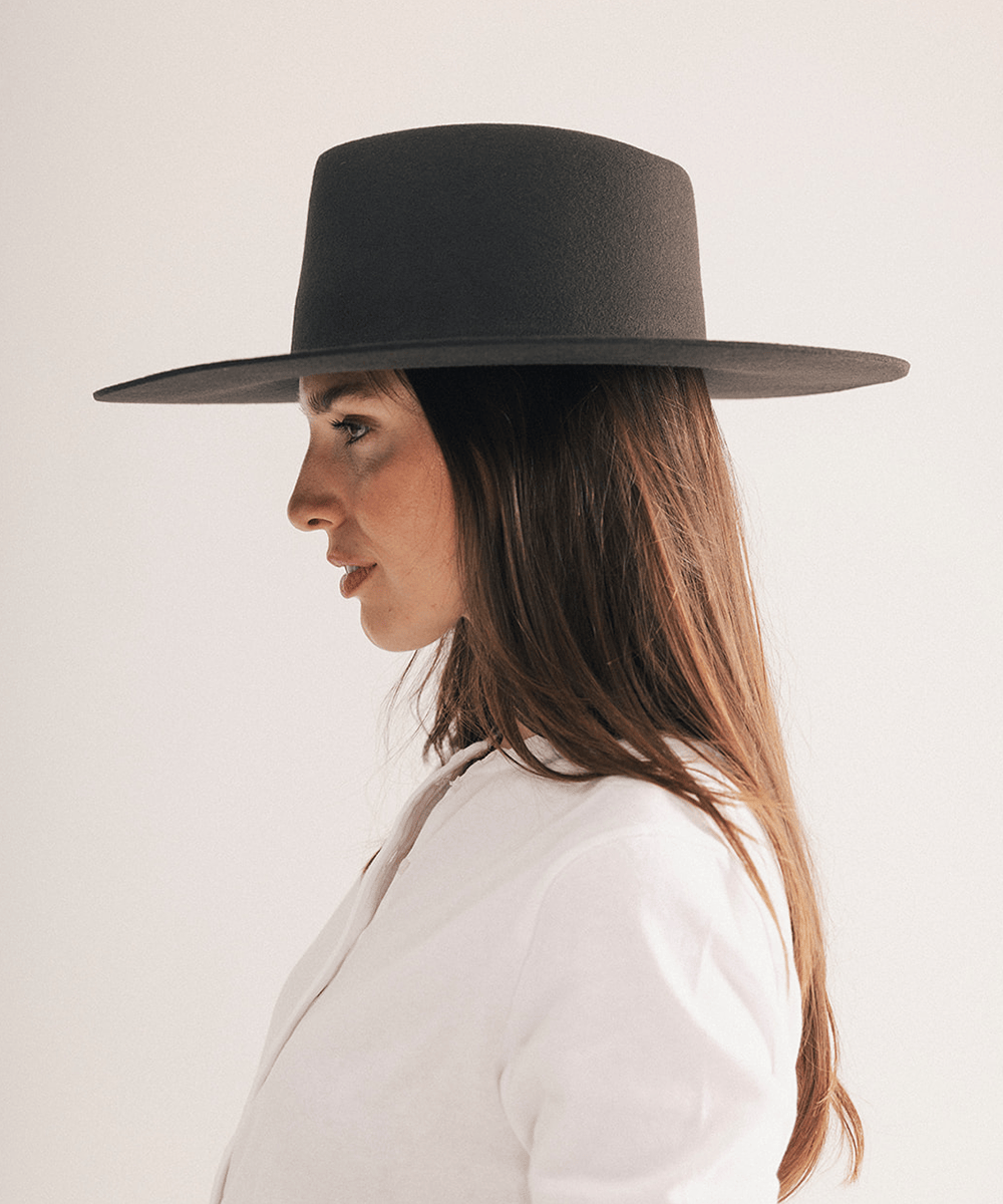 Woman wearing a wide brim felt hat on a white background #color_dark brown