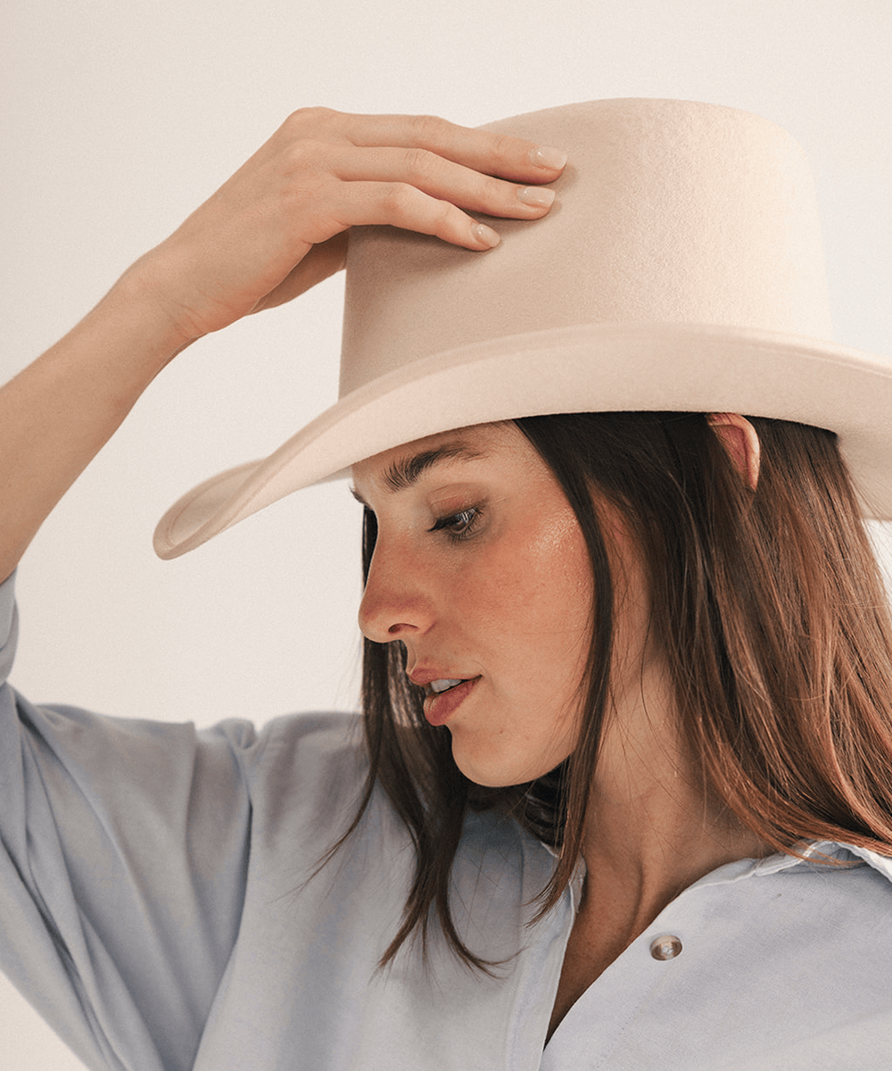 Woman wearing a beige felt hat on a white background #color_cream