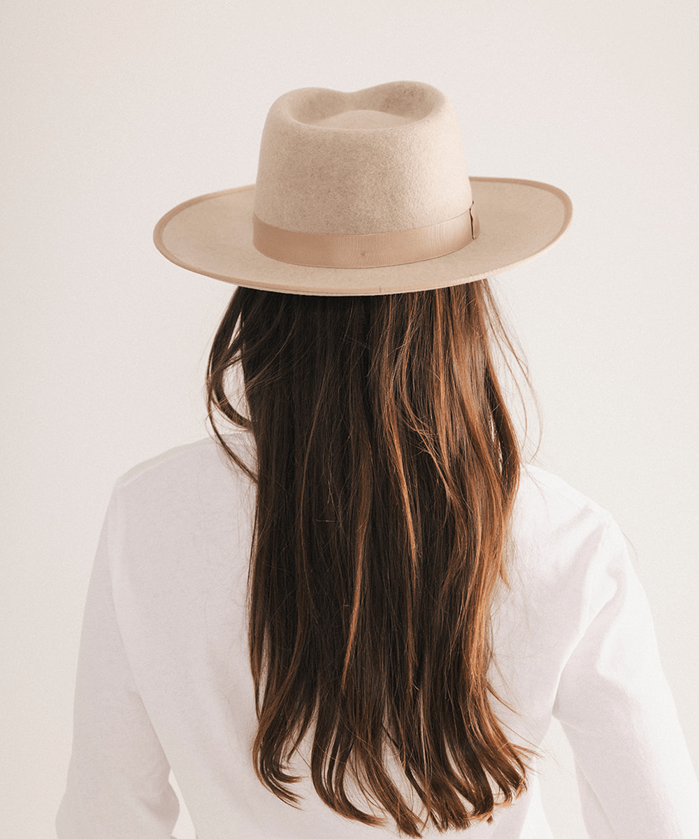 Woman wearing a fedora hat with a band on a white background #color_oatmeal