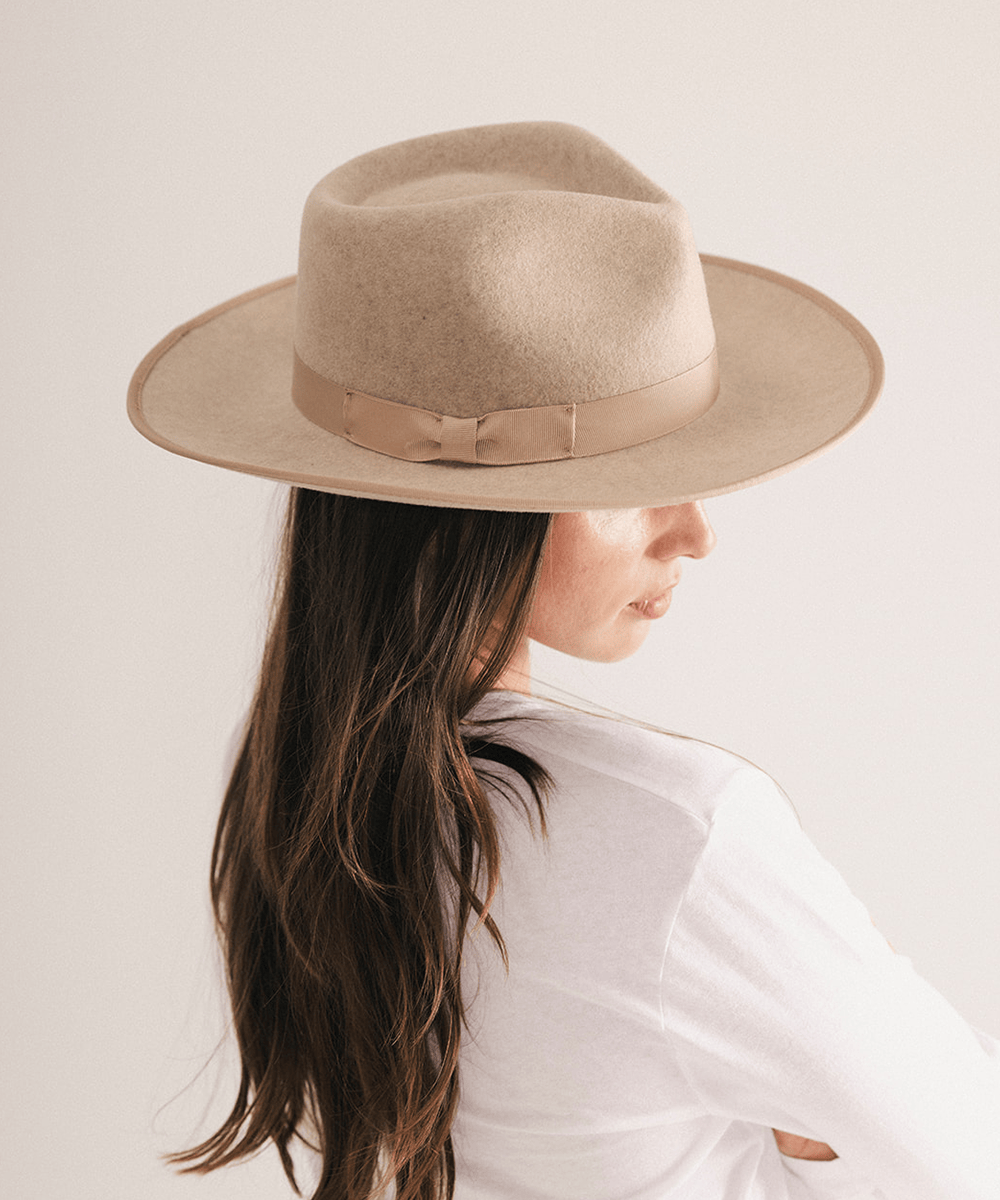 Woman wearing a fedora hat with a band on a white background #color_oatmeal