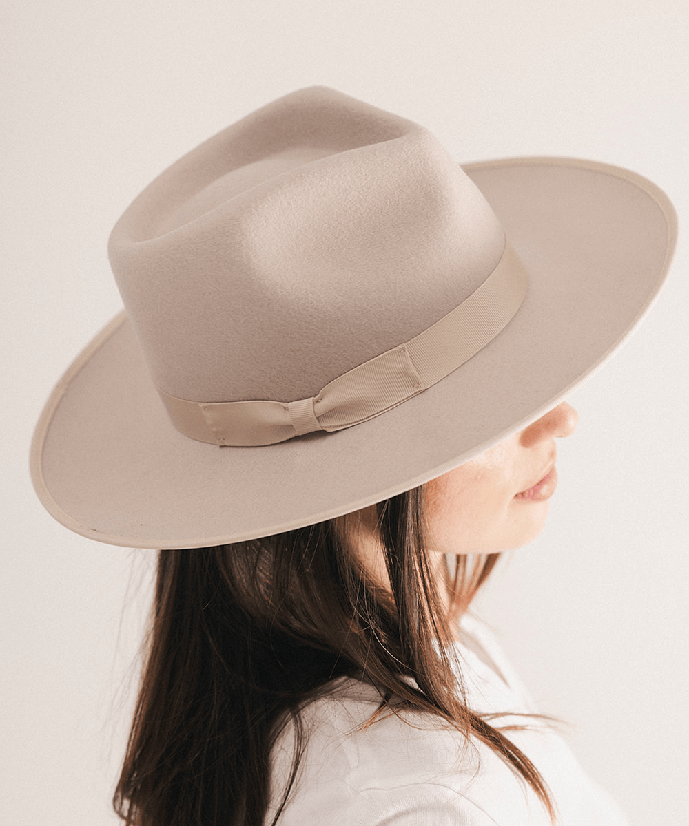 Woman wearing a fedora hat with a band on a white background #color_ivory