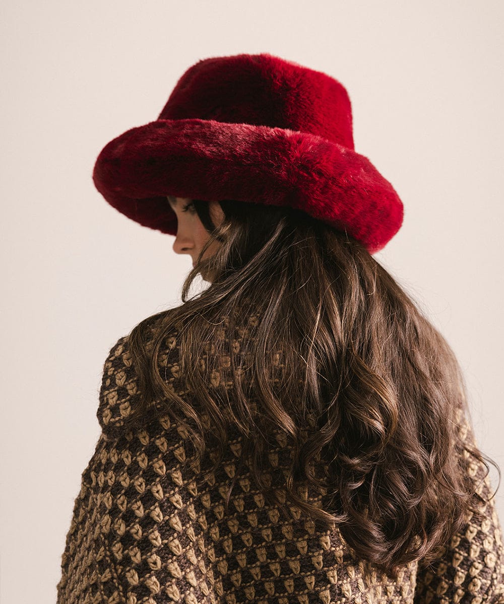 Person wearing a red fur hat and patterned coat on a plain background #color_burgundy