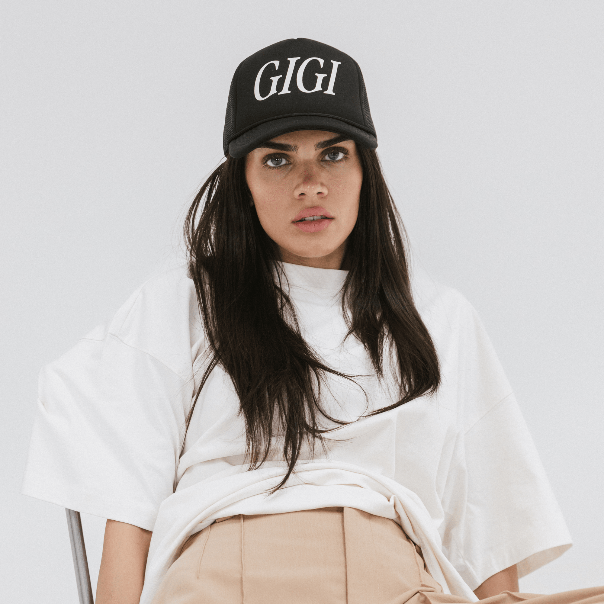 Gigi Pip trucker hats for women - Gigi Foam Trucker Hat - 100% polyester foam + mesh trucker hat with a curved brim featuring the word "Gigi" in a contrasting color as a design across the front panel [black]
