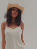 Woman wearing a straw hat against a plain background #color_natural
