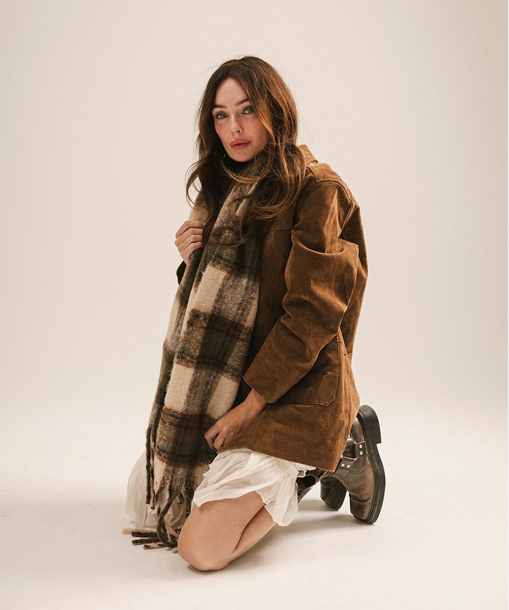 Woman wearing a brown coat and plaid scarf on a white background #color_cream - tan