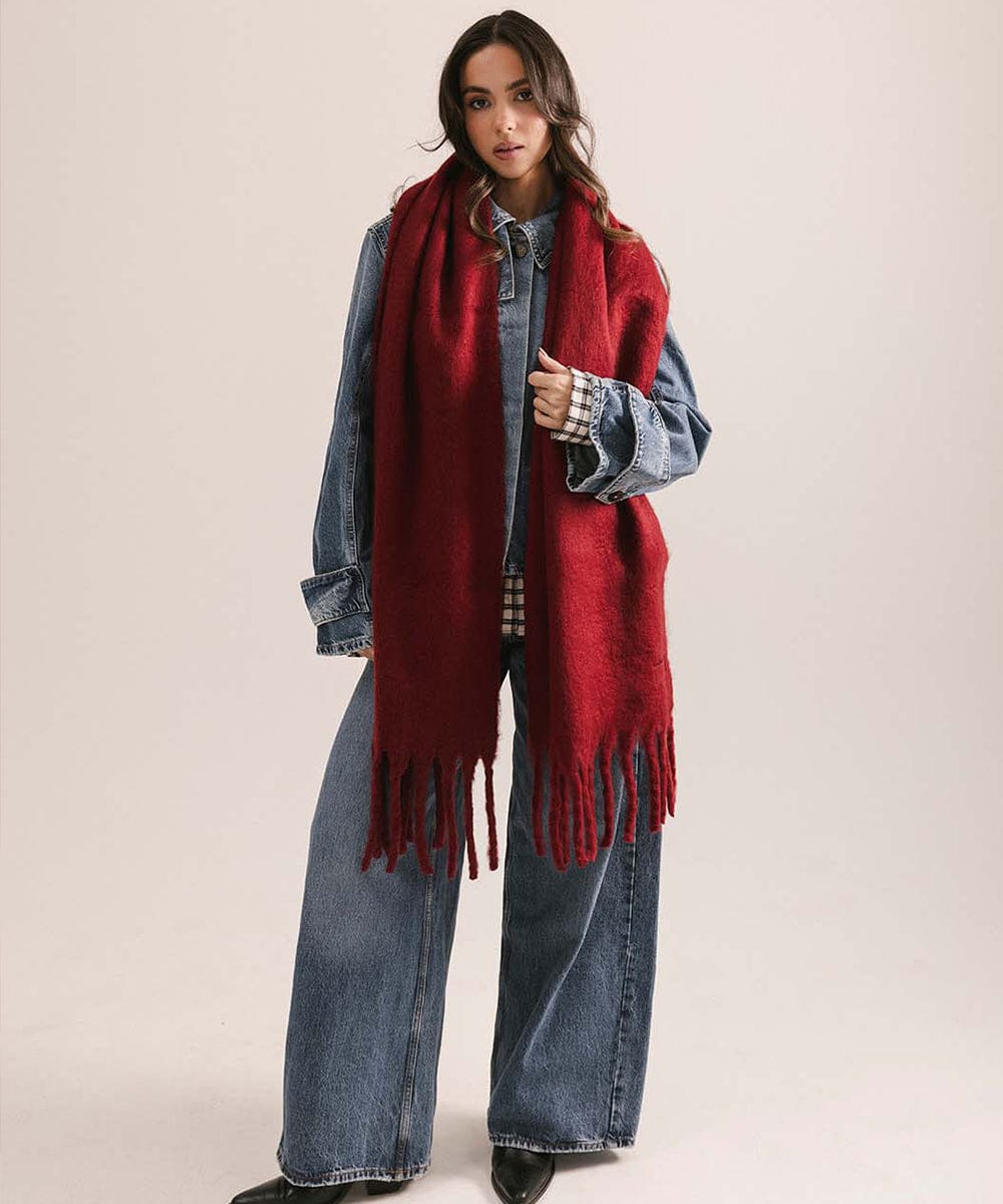 Woman wearing a red scarf, denim jacket, and jeans on a beige background #color_burgundy