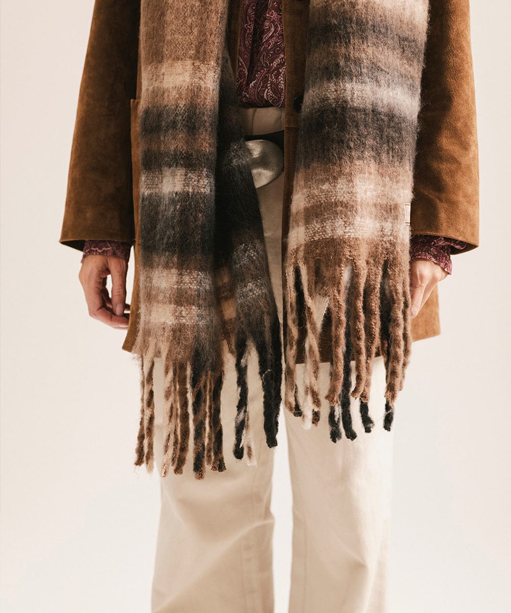 Person wearing a brown coat and plaid scarf with fringe on a light background #color_Brown - Black Plaid