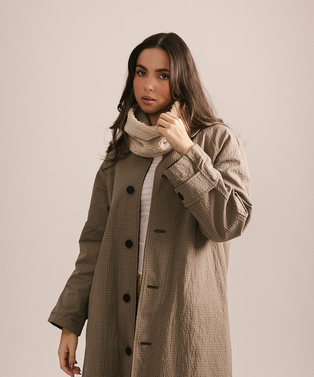 Woman wearing a long beige coat with a neutral background #color_cream