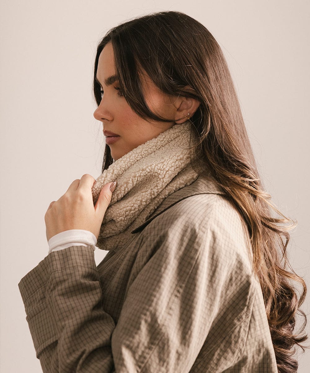Woman wearing a beige scarf and coat against a plain background #color_cream