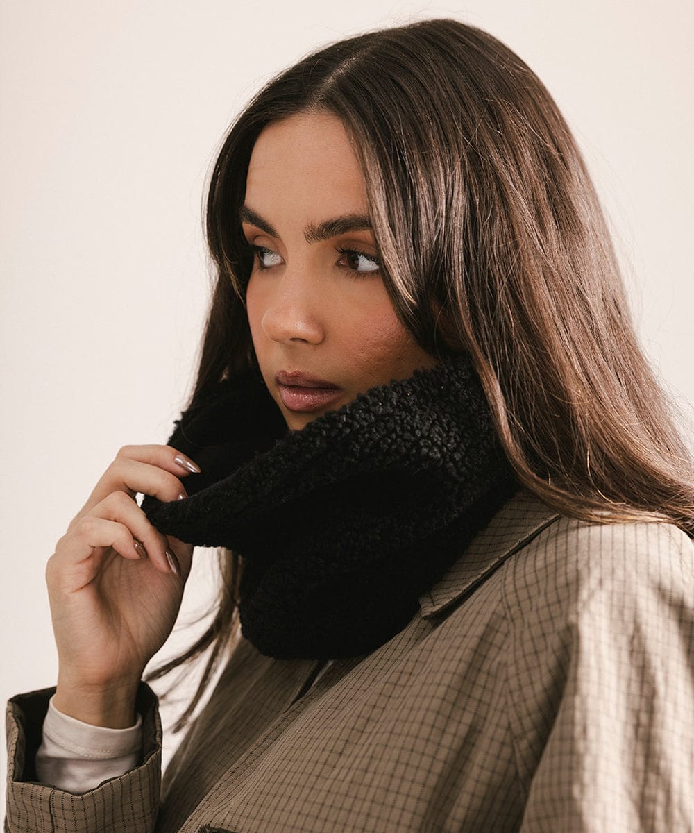 Woman wearing a black scarf with a neutral background #color_black