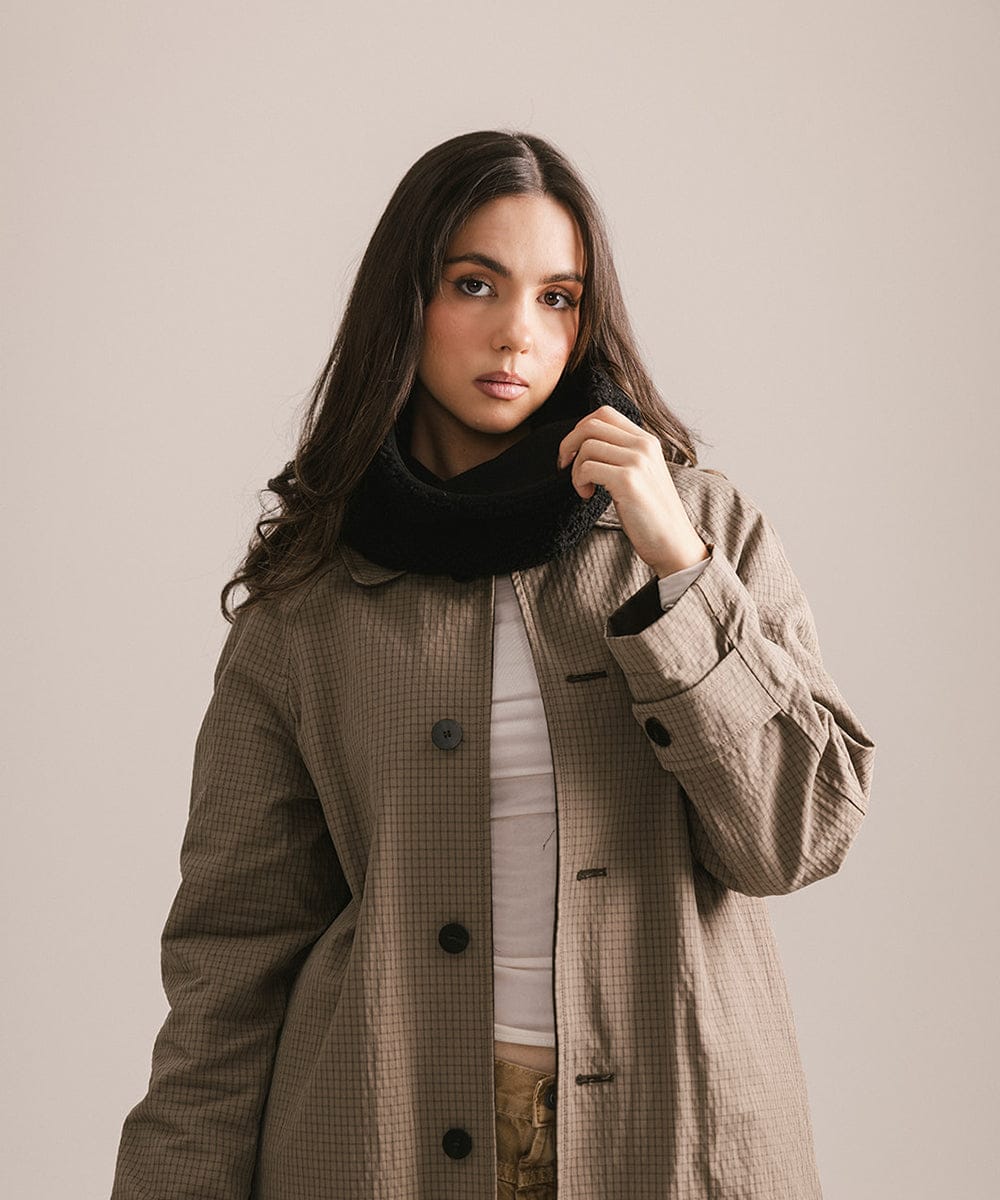 Woman wearing a brown coat with a neutral background #color_black