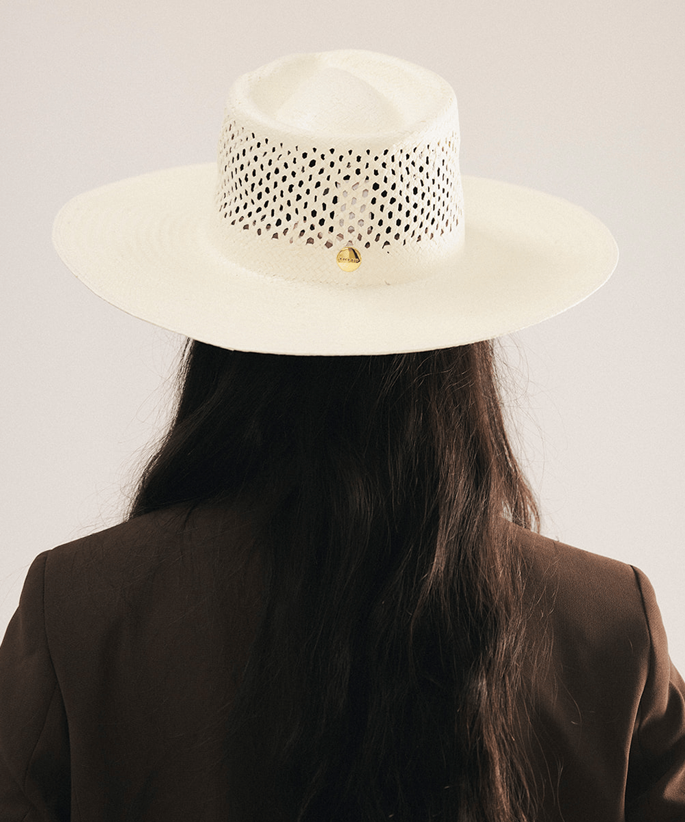 Woman wearing a natural white straw fedora hat with a wide brim and intricate venting details. #color_natural white