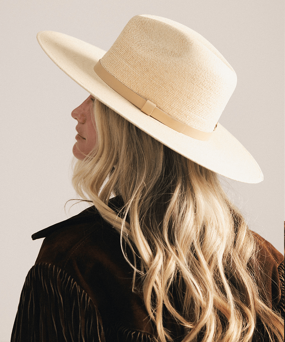 Woman wearing a natural colored Blake Wide Brim Fedora Hat with a flat wide brim and a tonal genuine leather band, displayed against a plain background. #color_natural