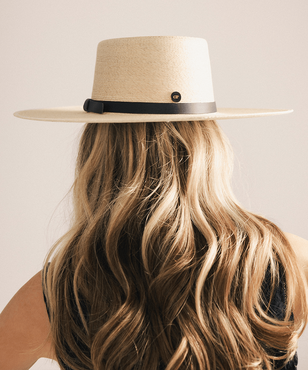 Woman wearing a beige straw hat against a white background #color_natural