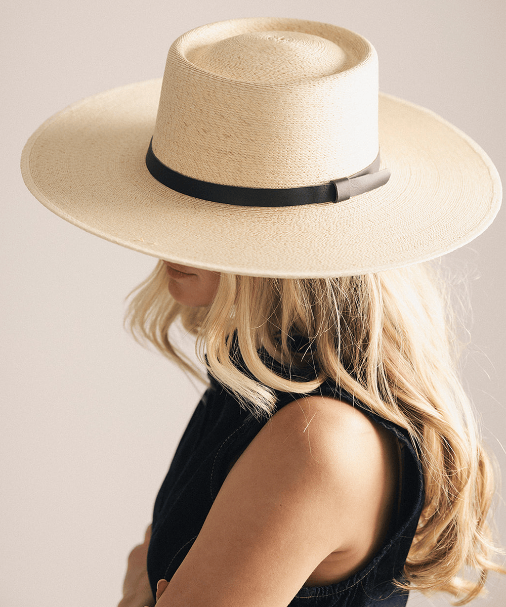 Woman wearing a beige straw hat against a white background #color_natural