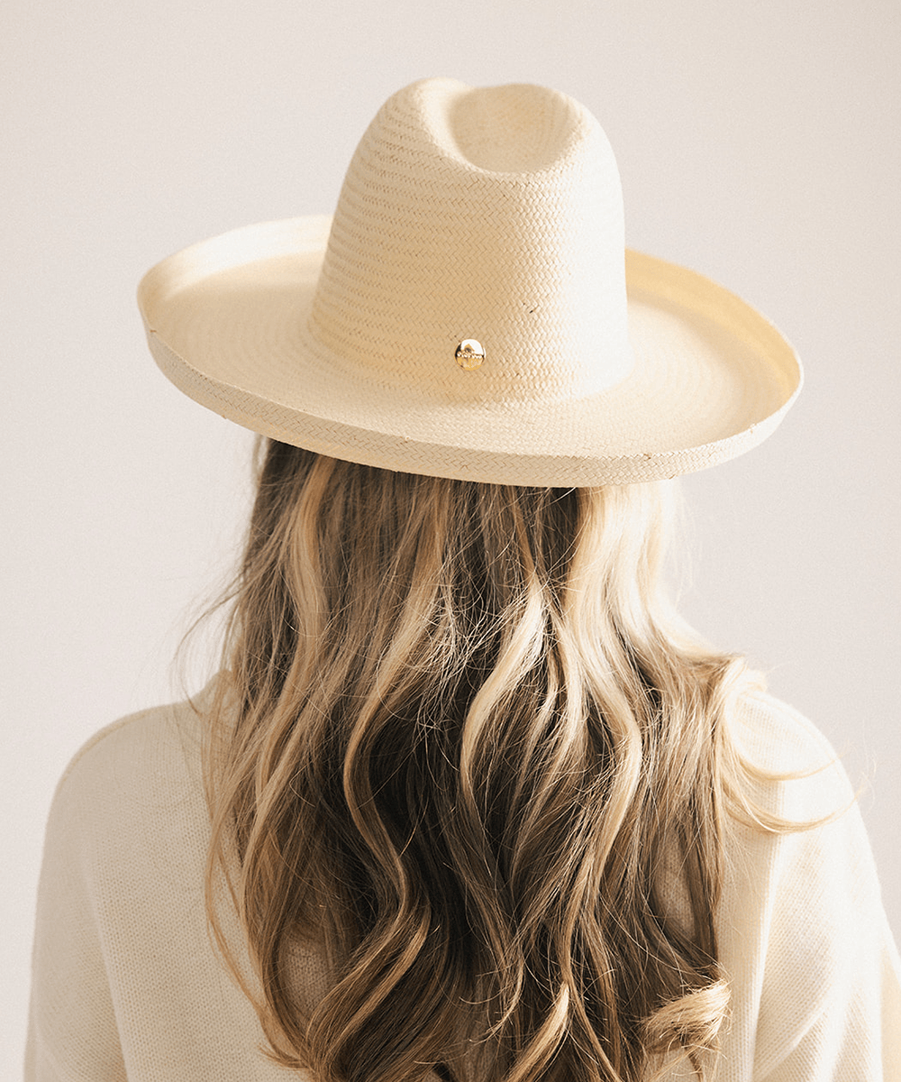 Woman wearing a natural colored pencil brim fedora hat made of paper straw, displayed against a white background. #color_natural